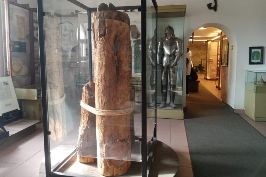 Первый зал музейной экспозиции. В центре представлены брёвна, которые являлись частью средневековой крепости Корела. Начало 14 века. 